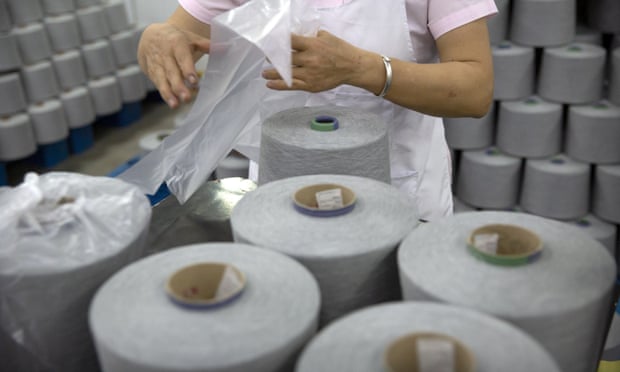 A worker packages spools of cotton yarn at a textile manufacturing plant in Xinjiang.