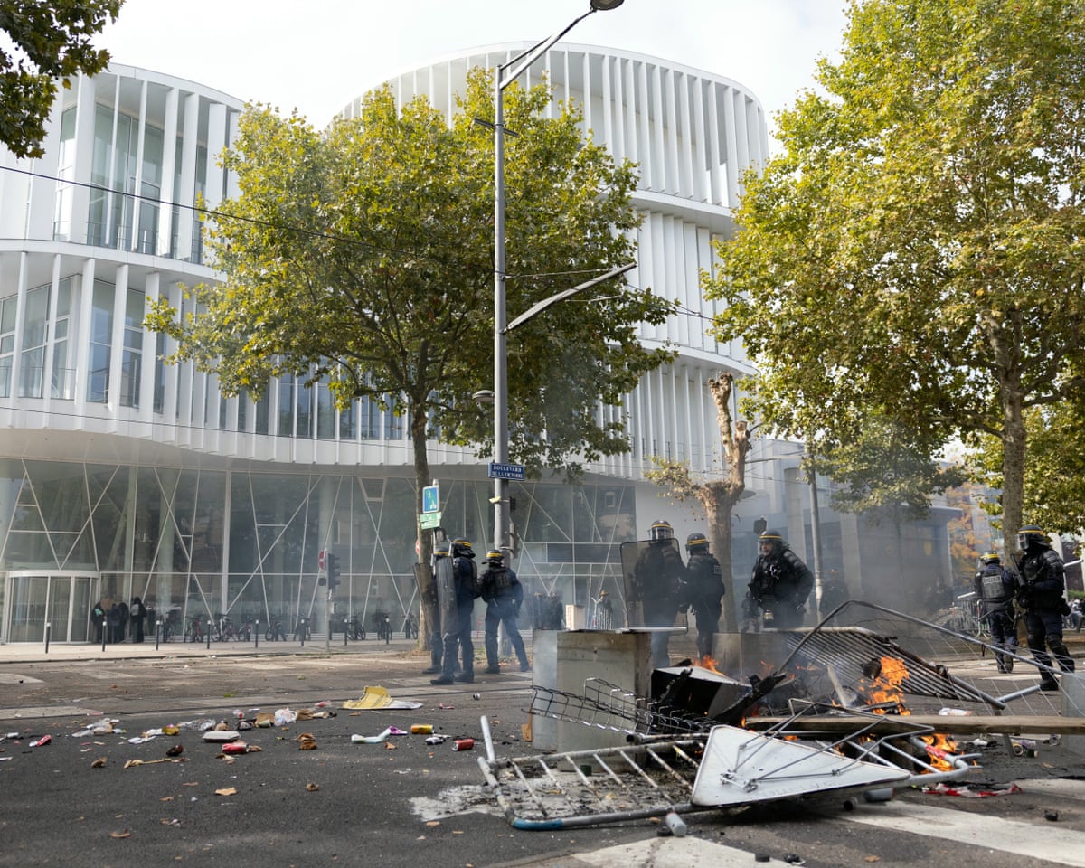 French police officers stand in front of burnt barriers and trash bags as students carry out a blocking protest at the Strasbourg University, in Strasbourg, eastern France.