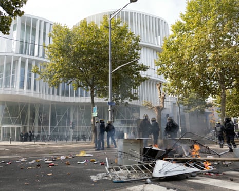 French police officers stand in front of burnt barriers and trash bags as students carry out a blocking protest at the Strasbourg University, in Strasbourg, eastern France.