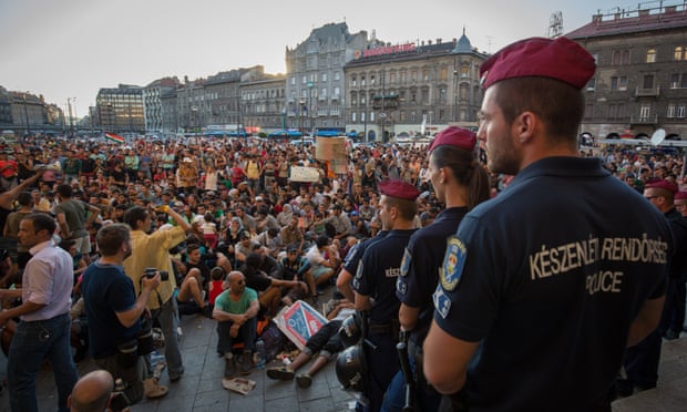 Hungarian police watch refugees gathered outside Keleti station in central Budapest last year.