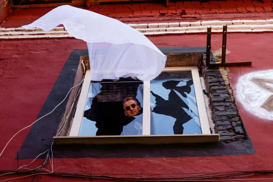 Ukrainian artist Misha Alekseenko watches his Broken Window installation from one of the windows at Closer nightclub.