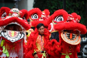 A group of people in a bright red lion dance costume