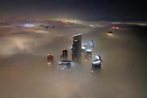 An aerial view of skyscrapers rising above the fog