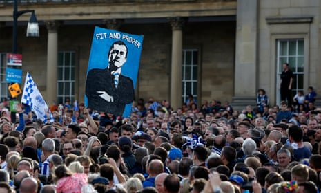The Huddersfield Town fans hold up a banner for the chairman and owner, Dean Hoyle, as they celebrate promotion to the Premier League. 