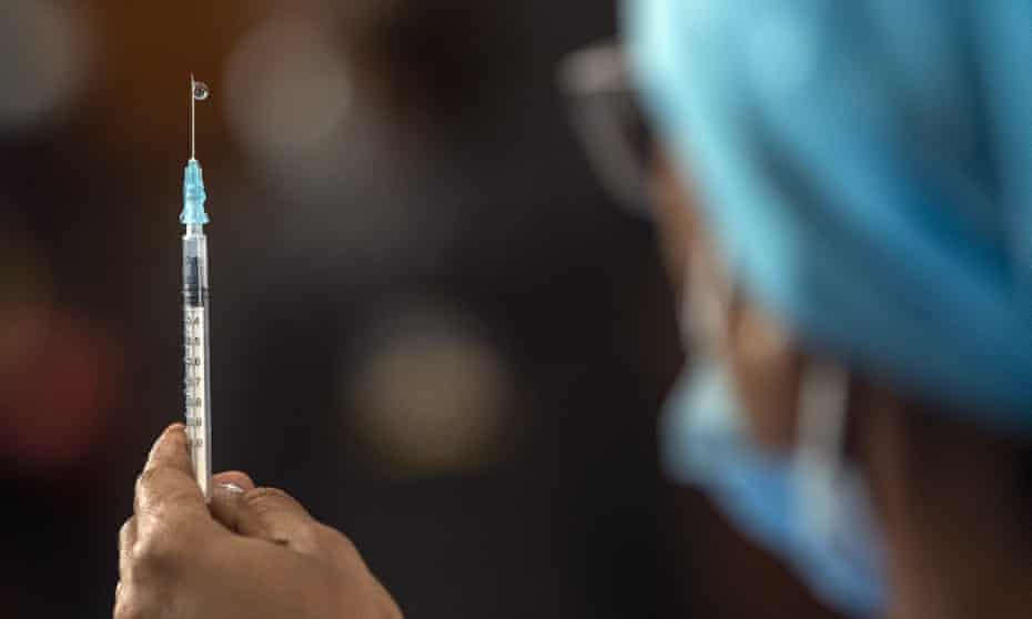 A healthcare worker prepares a vaccine