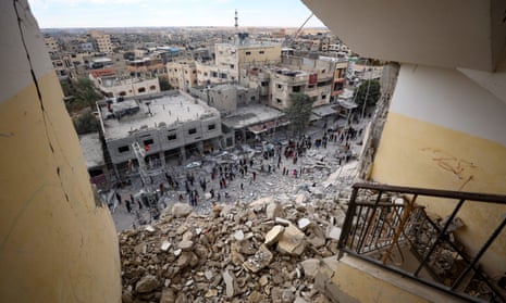 Palestinians inspect the area after an Israeli airstrike hit Al Masry Tower in Rafah.