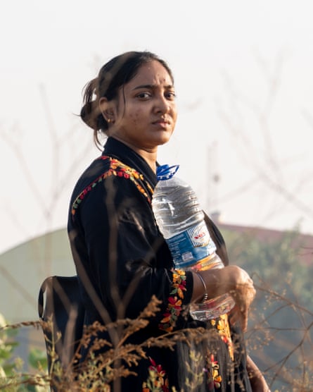 Neha holds a large plastic bottle filled with water