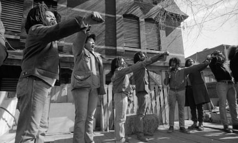 Members of Move show defiance to the police as they stand in front of their barricaded house in Philadelphia, Pennsylvania. 