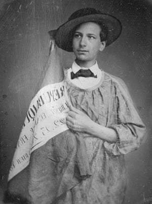 black and white photo of a man with a hat holding a banner