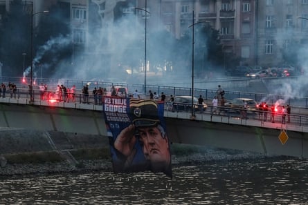 Supporters of the deceased Bosnian Serb general Ratko Mladic hold his picture and light flares on the Varadinski Bridge