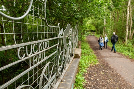 Three ramblers walking along a disused railway path between Horam and Heathfield, East Sussex, England.