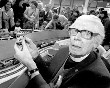 Awdry holds up a small model of Thomas the Tank Engine at an event attended by numerous people