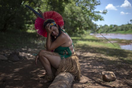 A woman from the Pataxo Ha-ha-hae community cries on the banks of the polluted Paraopeba River