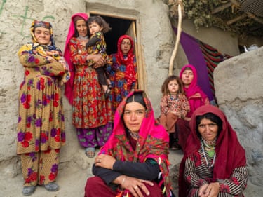 a group of women and children in colourful traditional dress face the camera