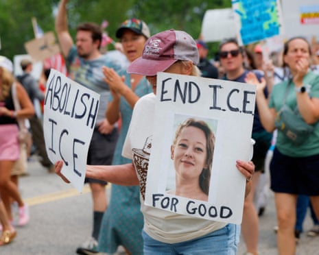 A woman holds a photograph of Renee Good, who was fatally shot by a federal immigration agent on 7 January in Minneapolis, as people protest outside an ICE facility in Scarborough, Maine.