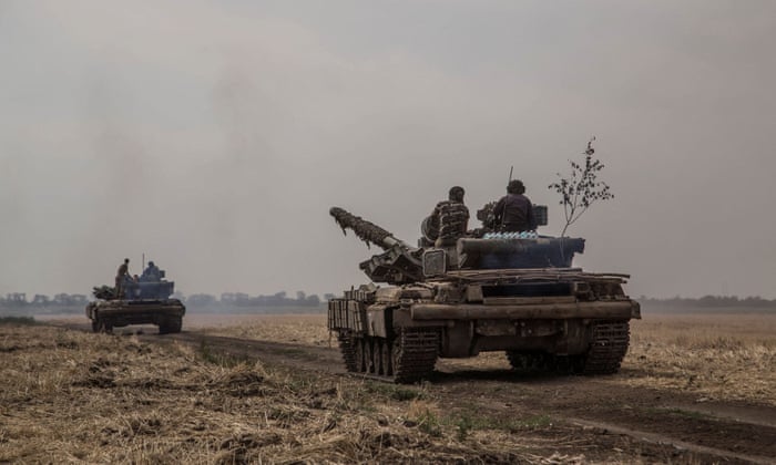 Ukrainian servicemen ride atop tanks near a front line in Mykolaiv region, Ukraine , on 10 August.