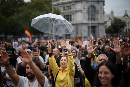 Demonstrators raise their arms in the air