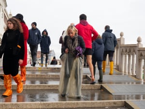 A woman stays dry by using plastic bags as waders