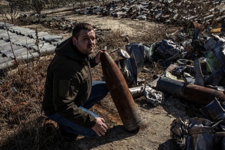 Dmytro Chubenko of the Kharkiv regional prosecutor’s office beside collected parts of Russian rockets at the ‘missile cemetery’ in Kharkiv