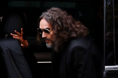 Russell Brand stepping out of his car outside court.