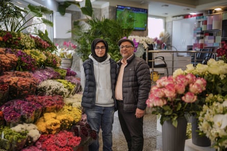 Sajedeh and Hassan in the shop surrounded by flowers