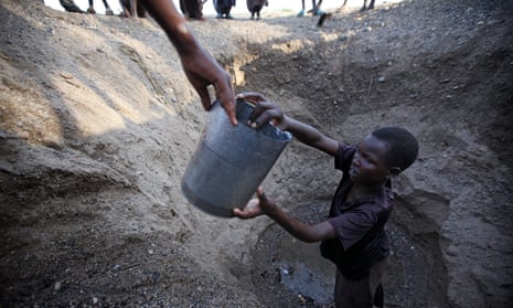 Children in northern Kenya dig a hole in a river bed to retrieve water. A Rwandan scientist has found a cheap way to make it safe to drink.