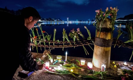 Flowers and candles placed during a vigil for those who died in a warehouse fire in Oakland.