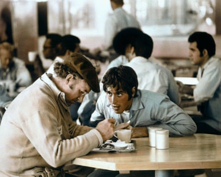 Gene Hackman and Al Pacino talking intensely in a cafe