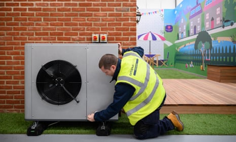 An engineer checks the installation of a heat pump on a model house within the Octopus Energy training facility in Slough, England