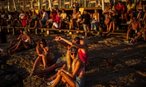 Tourists gather to watch the sunset in front of Cafe del Mar in Sant Antoni near Ibiza, Spain.