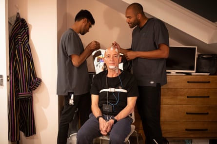 Phil seen having electrodes applied to his head and body at home by Julius Patrick (right), a sleep physiologist at IPDiagnostics. 3 April 2024