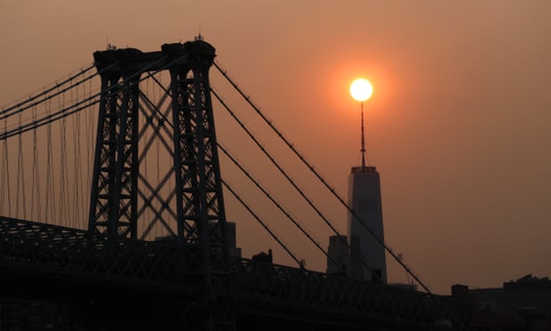 The sun sets behind the Manhattan Bridge and One World Trade Center in a haze created by smoke from the west coast wildfires this week.