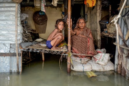 A woman and a young girl sit in their flooded house in Sunamganj, north-eastern Bangladesh, on 16 July.