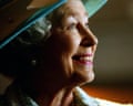 Queen Elizabeth II in a blue hat, smiling at something in the distance