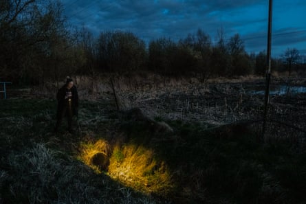 Agnieszka ilumina una tubería al aire libre por la noche con una linterna