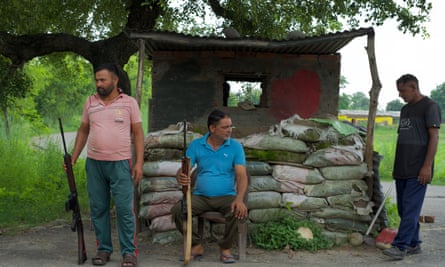 Three members of the Village Defence Guards with rifles and other weapons
