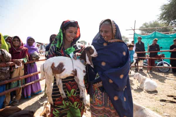 Rozina Ghulam Mustafa holds a goat, lasting adjacent to her mother