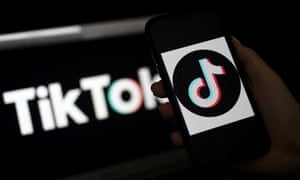 TikTok logo is displayed on the screen of an iPhone.