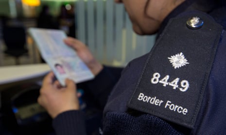 A Border Force officer checks a passport.