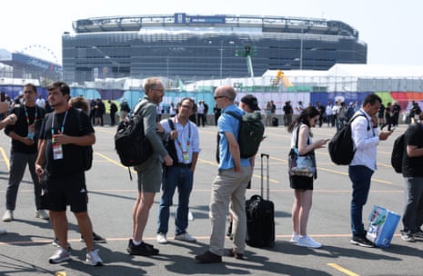Members of the media and staff queue to enter the stadium
