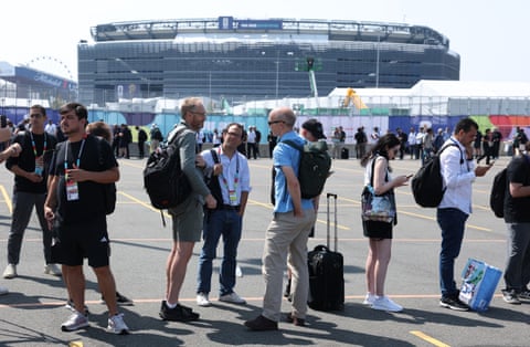 Members of the media and staff queue to enter the stadium