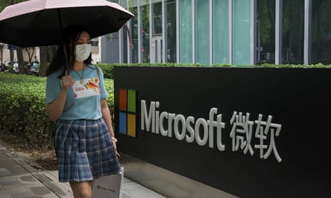 A woman wearing a face mask walks by the Microsoft office building