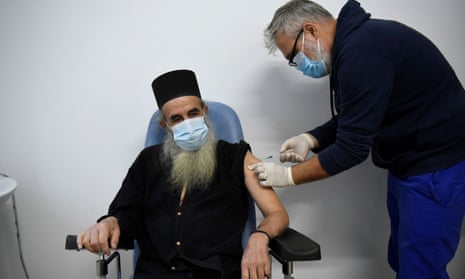 Father Makarios, 70, who had Covid last summer, receives his first jab in Mount Athos, Greece.