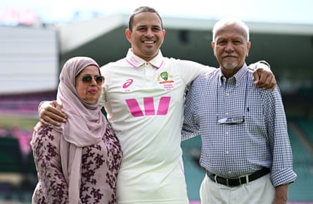 The Australian cricketer Usman Khawaja poses for a photograph with his parents after announcing his retirement from Test cricket.