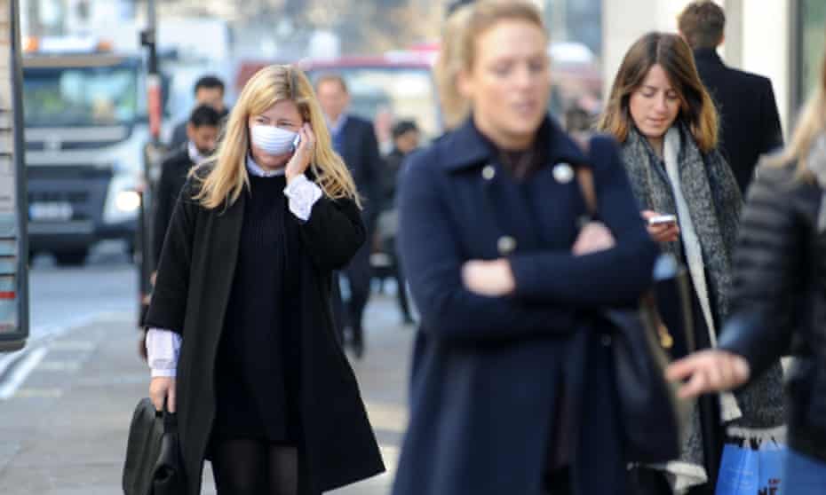 People wearing face masks in London. Air pollution is linked to the early deaths of about 40,000 people a year in the UK. 