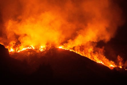 A raging orange fire on a black hillside.