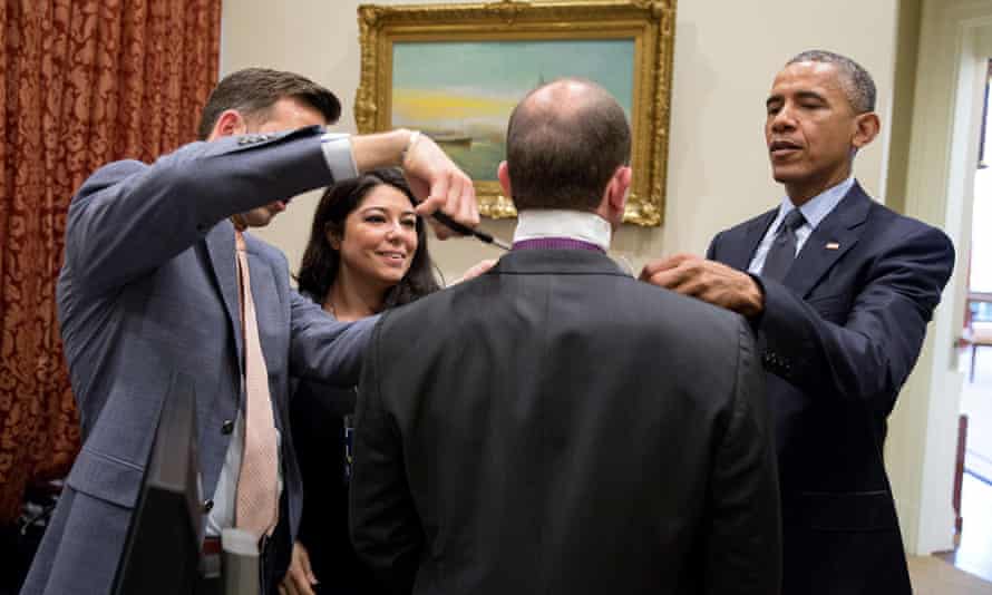 Rhodes is helped with his tie by Obama, personal aide Ferial Govashiri, and director of Oval Office operations Brian Mosteller