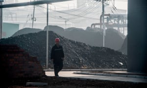 A worker walking by the main gate of a coal-to-oil plant in Changzhi in China’s northern Shanxi province.