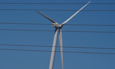 A wind turbine is seen behind electricity lines outside Bungendore near Canberra