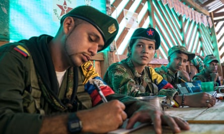 Guerrilla fighters Andrés and Daniela watch videos made by the Farc at a jungle camp.
